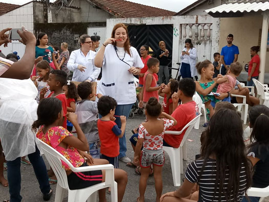 Voluntária conversando com crianças em ação social